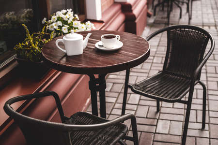 Street view of a summer terrace cafe with table and chairs.の写真素材