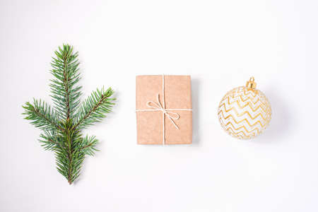 Christmas composition of a branch of fir, a gift and a silver ball on a white background. Flat lay, top view.の写真素材