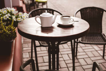 Street view of a summer terrace cafe with table and chairs.