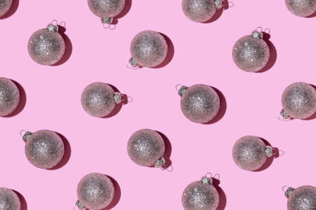 Pattern made of silver balls on pink background. Christmas or New Year concept. Flat lay.の写真素材