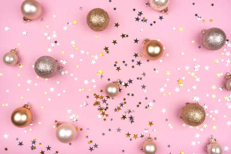 Festive pink background with gold and silver stars and Christmas balls. Flat lay, top view.