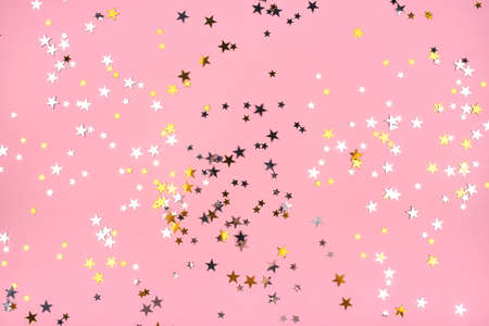 Golden and silver stars on pink pastel background. Flat lay, top view.の写真素材