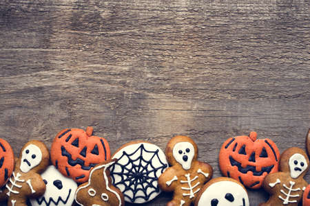 Halloween gingerbread cookies on wooden background. Flat lay. Copy space for your text.の写真素材