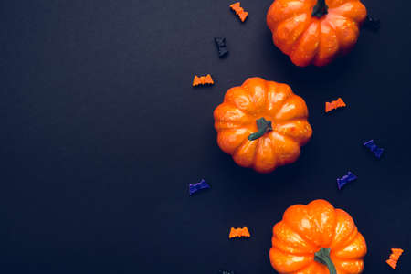 Halloween holiday background with pumpkins and bats. Flat lay, top view. Copy space for your text.の写真素材