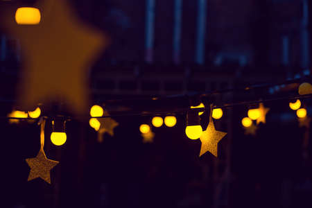Garland with lights and stars in a street bar in the evening.の写真素材