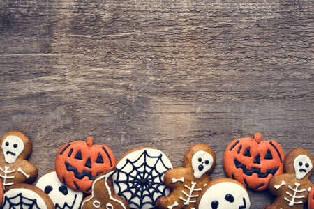Halloween gingerbread cookies on wooden background. Flat lay. Copy space for your text.の写真素材