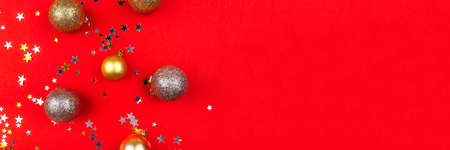 Festive red background with gold and silver stars, christmas balls and snowflakes. Flat lay, top...