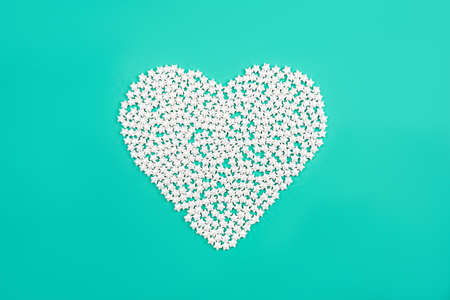Heart of small white stars on a mint background. Holiday concept. Flat lay, top view.の写真素材