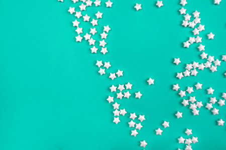 Little white stars on mint background. Holiday concept. Flat lay, top view.の写真素材