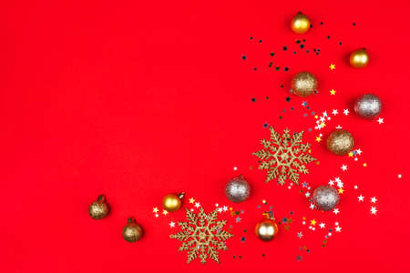 Festive red background with gold and silver stars, christmas balls and snowflakes. Flat lay, top view.の写真素材