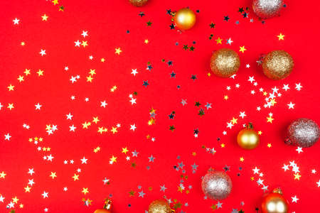 Festive red background with gold and silver stars and christmas balls. Flat lay, top view.の写真素材