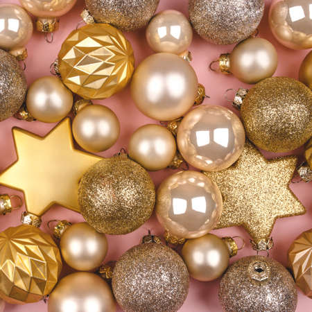 Festive pink background with gold and silver Christmas stars and balls. Flat lay, top view.の写真素材