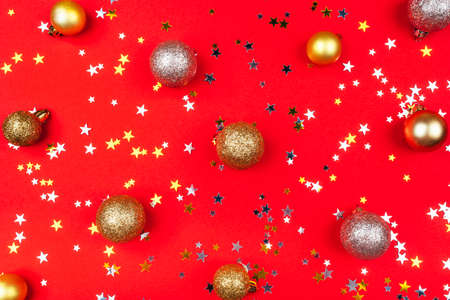 Festive red background with gold and silver stars, christmas balls and snowflakes. Flat lay, top view.の写真素材