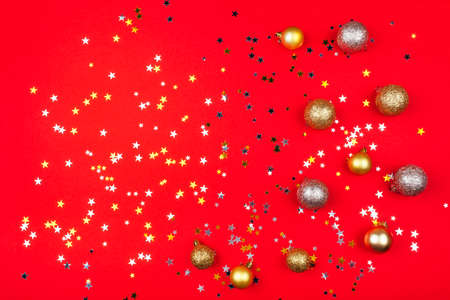 Festive red background with gold and silver stars and christmas balls. Flat lay, top view.の写真素材