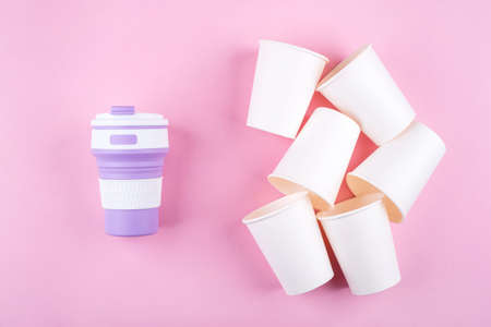 Reusable coffee cup vs disposable cups. Pink background. Zero waste concept.の写真素材