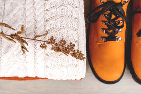 A pile of warm clothes and boots on the table. Spring-Summer 2020 Colors.