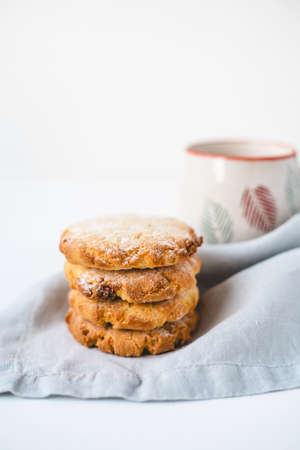 Stacked cookies on a linen napkin and a cup of coffee. Close up.の写真素材