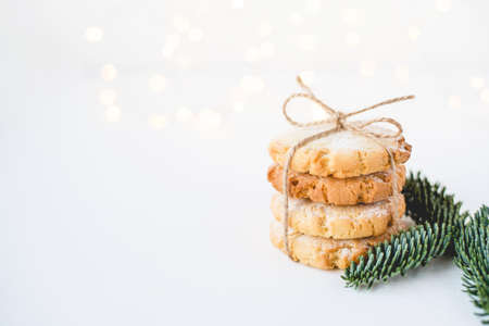 Composition of fresh cookies and fir branch on white wooden table. Close up.の写真素材