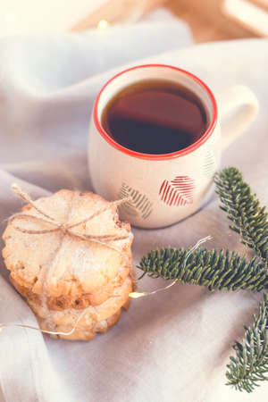 Composition of fresh cookies, cup of tea and fir branches on a wooden tray. Holiday concept. Close up.の写真素材