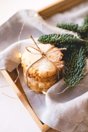 Composition of fresh cookies and spruce branches on a wooden tray. Holiday concept. Close up.の写真素材