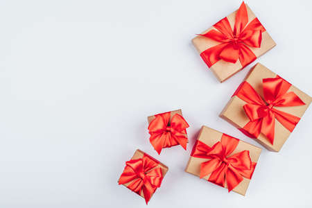 Frame of cardboard gift boxes with red bows on white background. Flat lay, top view. Copy space for text.の写真素材