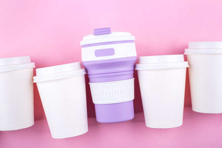 Reusable coffee cup vs disposable cups. Pink background. Zero waste concept.の写真素材