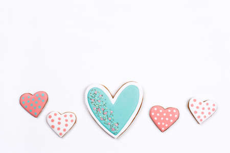 Gingerbread cookies with frosting in the shape of a heart on white background. Valentines day concept. Flat lay, top view, copy space for text.の写真素材