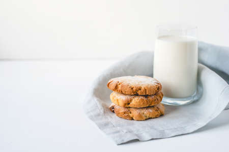 Stacked cookies on a linen napkin and a glass of milk. Close up.の写真素材