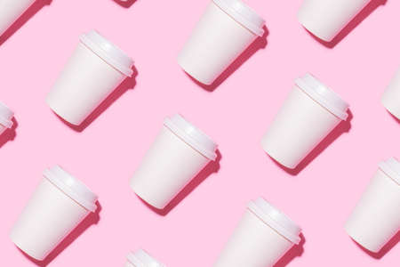 Pattern of disposable coffee cups on a pink background. Flat lay.の写真素材