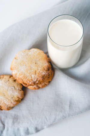 Stacked cookies on a linen napkin and a glass of milk. Close up. Top view.の写真素材
