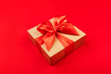 One cardboard gift box with bow on red background.の写真素材