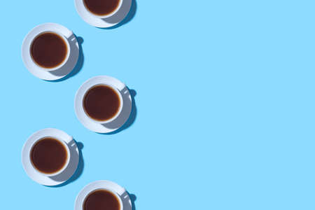 Frame of cups of black coffee or tea on a blue background. Flat lay, top view. Copy space for text.の写真素材