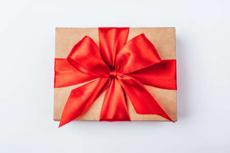 Cardboard gift box with red bow on white background. Flat lay. Top view.の写真素材