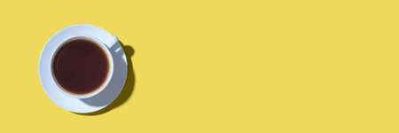 A cup of black coffee or tea on a yellow background. Minimal concept. Flat lay, top view.の写真素材