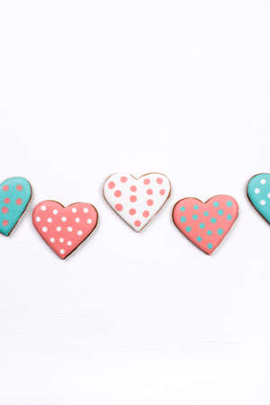 Gingerbread cookies with frosting in the shape of a heart on white background. Valentines day concept. Flat lay, top view.の写真素材