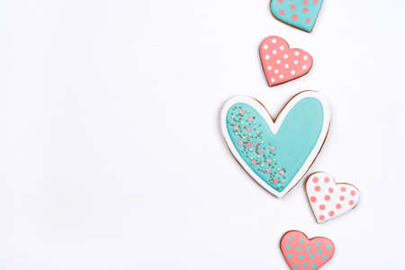 Gingerbread cookies with frosting in the shape of a heart on white background. Valentines day concept. Flat lay, top view, copy space for text.の写真素材