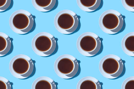 Pattern of cups of black coffee or tea on a blue background. Flat lay, top view.の写真素材