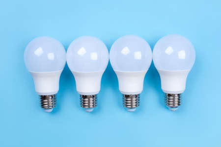 Four LED bulbs on blue background. Saving energy concept. Ftat lay. Top view.の写真素材