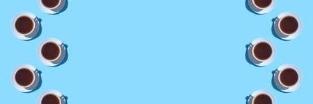 Frame of cups of black coffee or tea on a blue background. Flat lay, top view. Copy space for text.の写真素材
