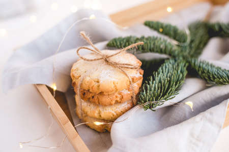 Composition of fresh cookies and spruce branches on a wooden tray. Holiday concept. Close up.の写真素材