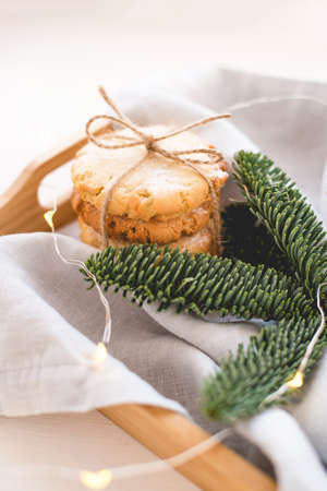 Composition of fresh cookies and spruce branches on a wooden tray. Holiday concept. Close up.の写真素材