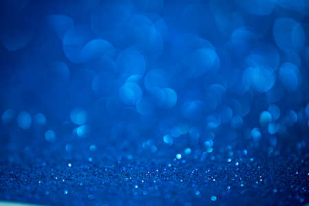 Abstract blue sparkle background with bokeh. Defocused sequin light. Main color of year 2020.の写真素材