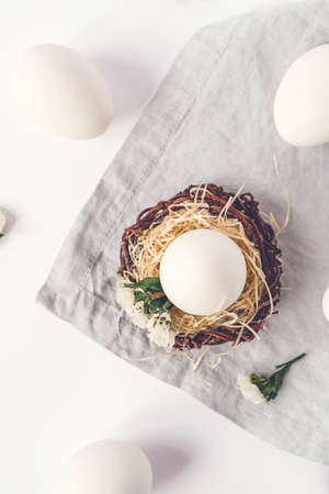 Light Easter background with white Easter eggs. Flat lay, top view.