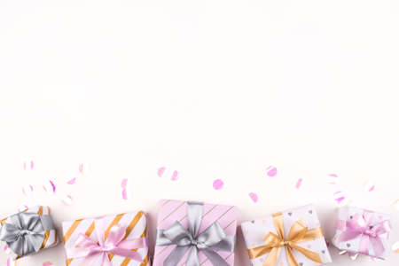 Set of gift boxes with bows and confetti on a white background. Flat lay composition. Birthday, christmas, wedding or another holiday concept.の写真素材