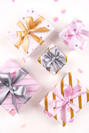 Set of gift boxes with bows and confetti on a white background. Flat lay composition. Birthday, christmas, wedding or another holiday concept.の写真素材