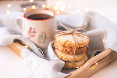 Fresh cookies and cup of tea on a wooden tray. Holiday concept. Close up.の写真素材