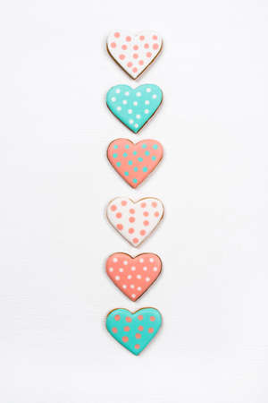 Gingerbread cookies with frosting in the shape of a heart on white background. Valentines day concept. Flat lay, top view.の写真素材