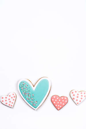 Gingerbread cookies with frosting in the shape of a heart on white background. Valentines day concept. Flat lay, top view, copy space for text.の写真素材
