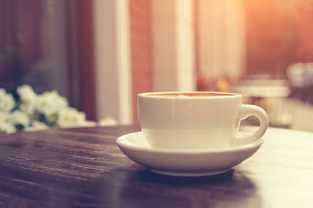 View of a summer terrace cafe with cup of cappuccino on the table.の写真素材