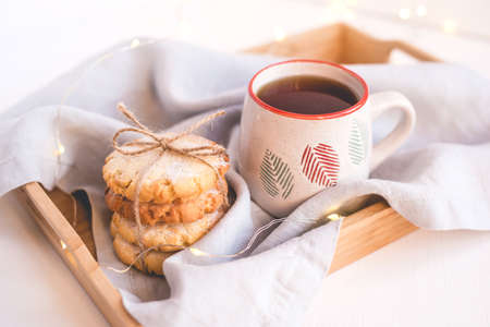 Fresh cookies and cup of tea on a wooden tray. Holiday concept. Close up.の写真素材
